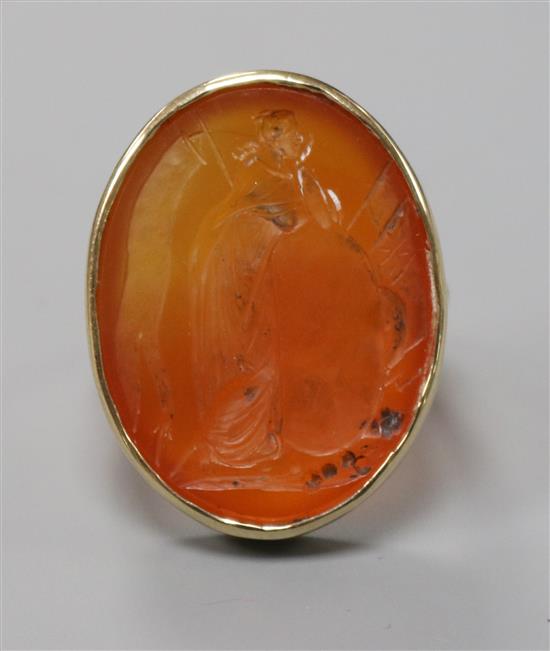 A yellow metal and intaglio carnelian set oval ring, carved with classical figure, size J.